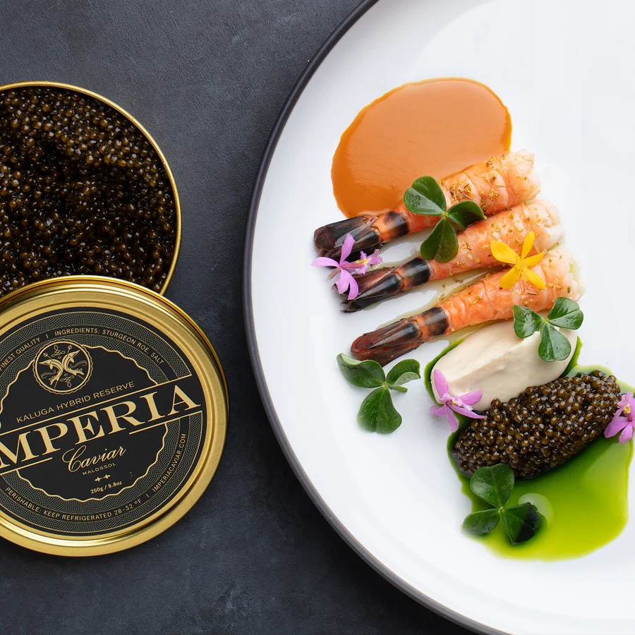 Imperia Caviar served with prawns and garnishes beside an open tin of caviar.