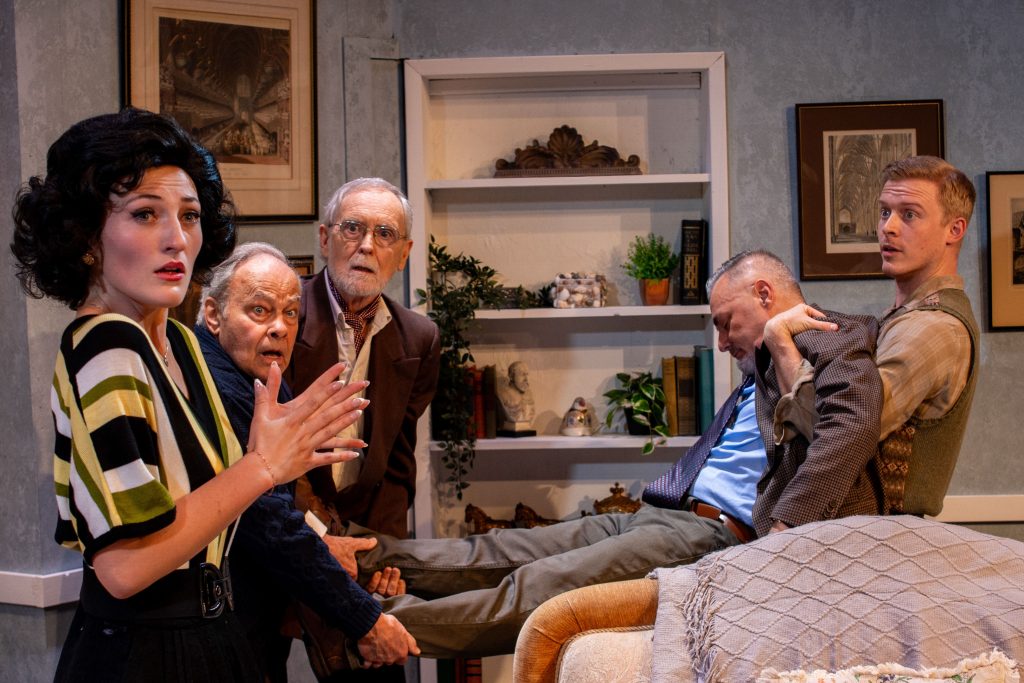 Cast members react in shock around an unconscious man during The Group Rep’s Spider’s Web at the Lonny Chapman Theatre.