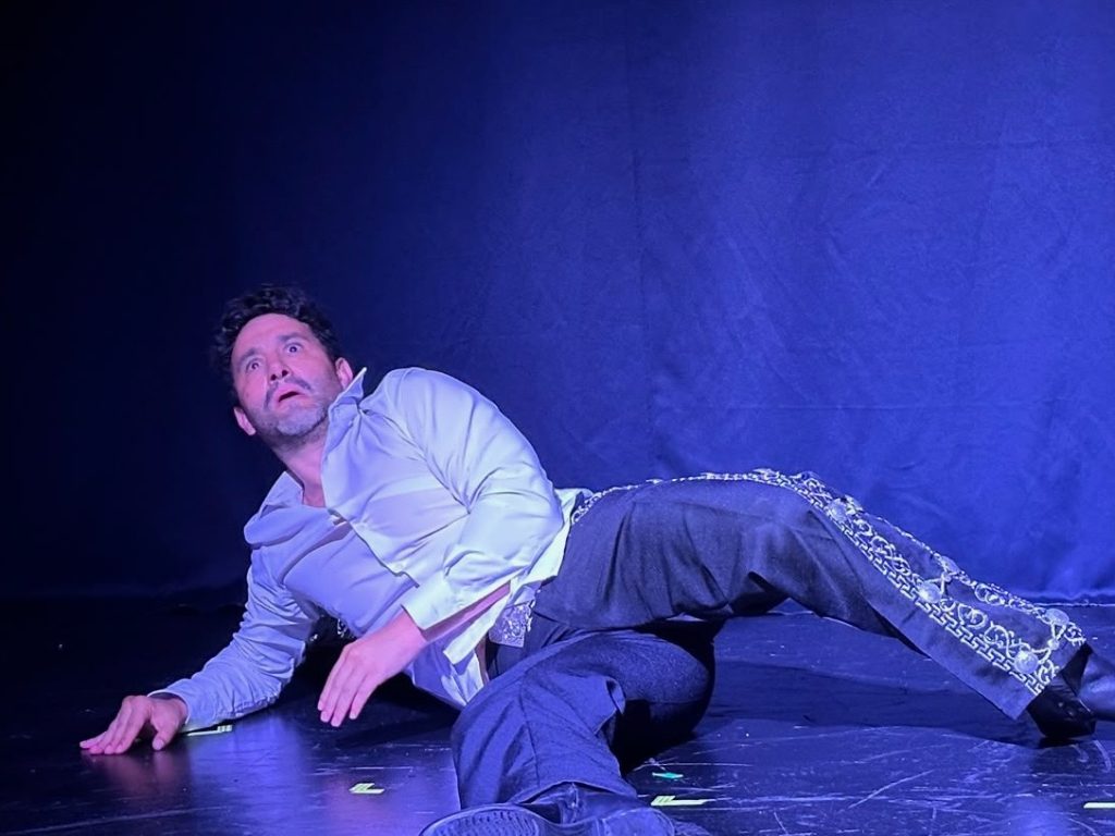 Eduardo Enrikez lies onstage during a dramatic moment in The Last Song at Whitefire Theatre.