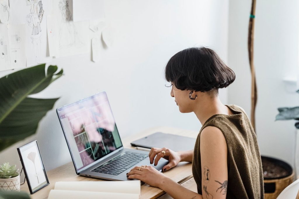 Artist working on a laptop in a bright studio, representing the creative and financial realities of freelance work.