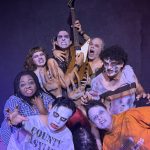 Eight performers in grotesque zombie makeup and torn costumes pose menacingly for Zombie Joe's Urban Death Tour of Terror ULTRA 2026.