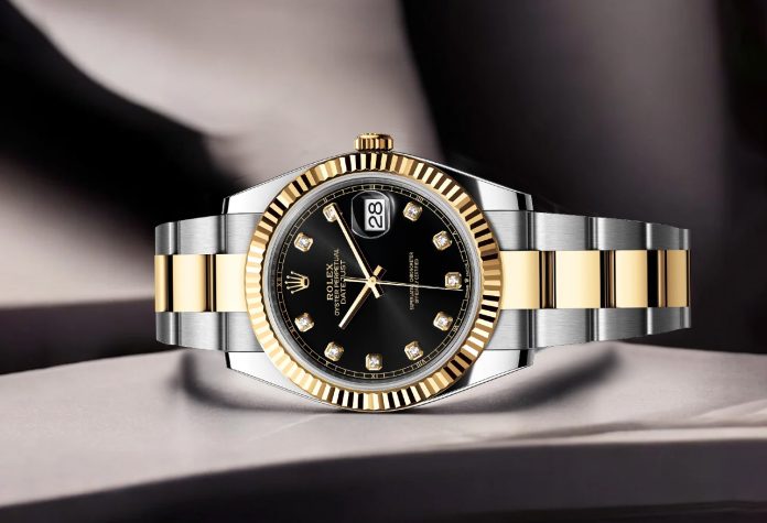 Pre-owned Rolex Datejust with black dial, diamond hour markers, gold fluted bezel and two-tone bracelet.