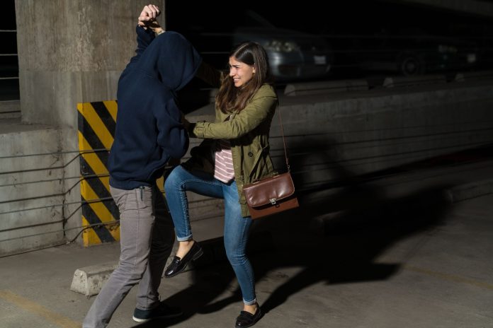 Woman defending herself from an attacker in a parking garage, illustrating self defence law in Canada.