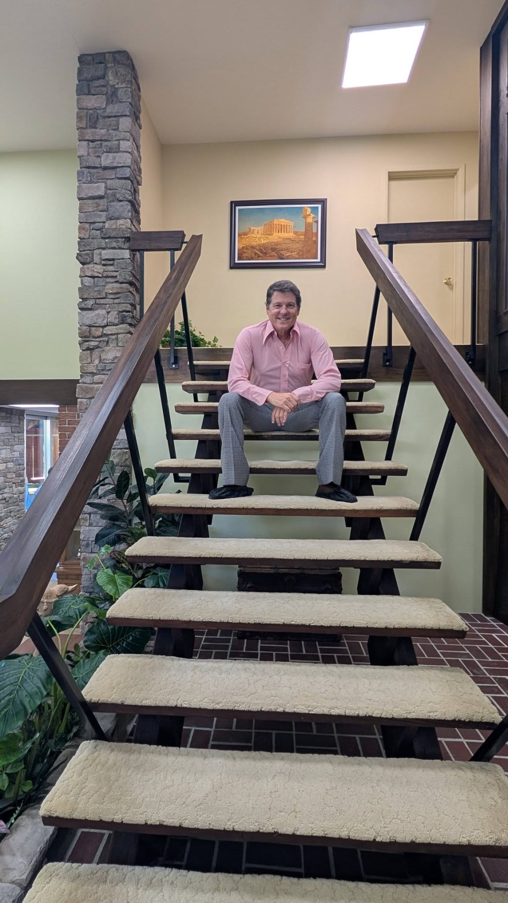Jack Witt sits on the iconic floating staircase inside The Brady Bunch house in Studio City.