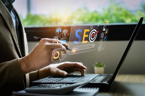 seo computer Person using a laptop and stylus with a digital SEO interface, search bar, target icon and analytics graphics.